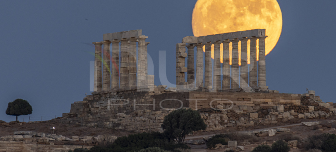 The Full Buck Moon rises behind the ancient Greek Temple of Poseidon on Cape Sounion in Greece on July 20, 2024 
