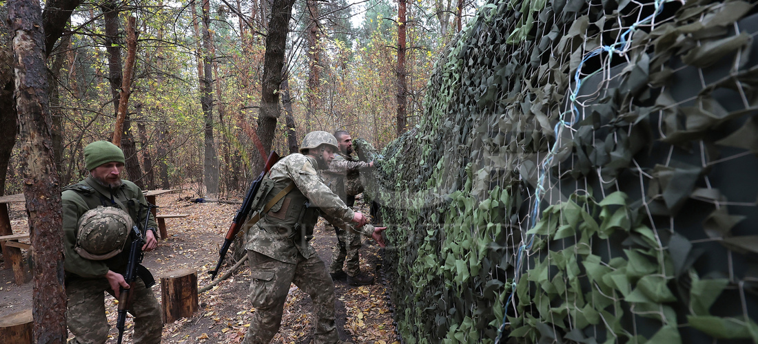 Soldiers of Ukraine's 154th Separate Mechanized Brigade man a 2S1 Gvozdika self-propelled howitzer covered with camouflage netting at positi...