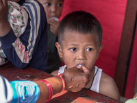 Health Worker Administers Vitamin A Capsule To Child In Nepal.