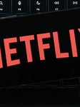 Netflix Logo Displayed On IPhone With MacBook Air Keyboard Background