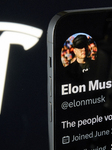 Elon Musk’s X Profile With Tesla’s Logo In The Background