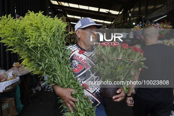 A person holds two bouquets of flowers inside the Jamaica Market in Mexico City where dozens of people came to buy flowers and gifts for Mot...