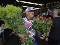 A person holds two bouquets of flowers inside the Jamaica Market in Mexico City where dozens of people came to buy flowers and gifts for Mot...