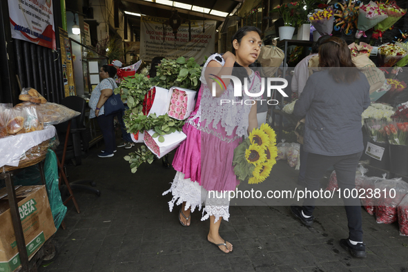 A woman holds a bouquet of flowers inside the Jamaica Market in Mexico City where dozens of people came to buy flowers and gifts for Mother'...