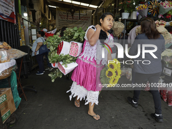 A woman holds a bouquet of flowers inside the Jamaica Market in Mexico City where dozens of people came to buy flowers and gifts for Mother'...