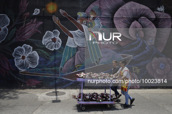 Two people carry flowers outside the Jamaica Market in Mexico City where dozens of people came to buy flowers and gifts for Mother's Day, wh...