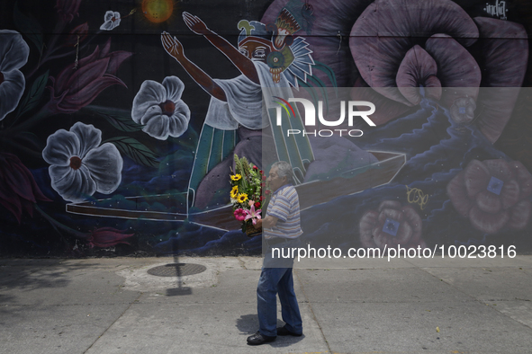 A man holds a bouquet of flowers outside the Jamaica Market in Mexico City where dozens of people came to buy flowers and gifts for Mother's...