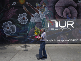 A man holds a bouquet of flowers outside the Jamaica Market in Mexico City where dozens of people came to buy flowers and gifts for Mother's...