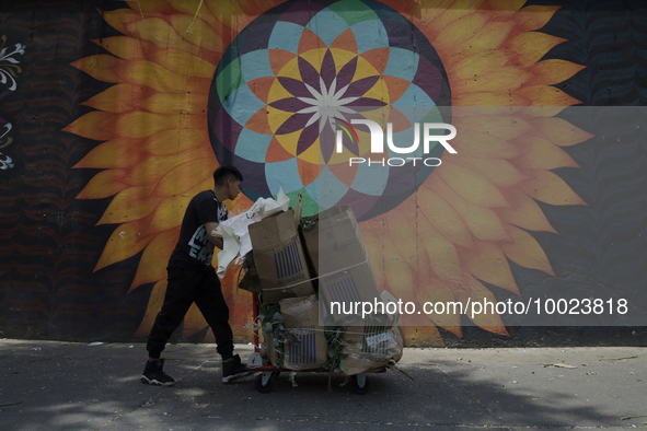 A person carries boxes outside the Jamaica Market in Mexico City where dozens of people came to buy flowers and gifts for Mother's Day, whic...