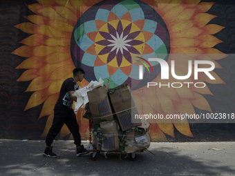 A person carries boxes outside the Jamaica Market in Mexico City where dozens of people came to buy flowers and gifts for Mother's Day, whic...