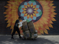 A person carries boxes outside the Jamaica Market in Mexico City where dozens of people came to buy flowers and gifts for Mother's Day, whic...