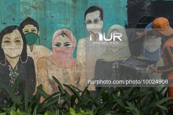 Municipal worker removed a mural promoting awareness of the coronavirus disease (Covid-19) and replaced it with another image in Jakarta, In...