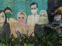 Municipal worker removed a mural promoting awareness of the coronavirus disease (Covid-19) and replaced it with another image in Jakarta, In...