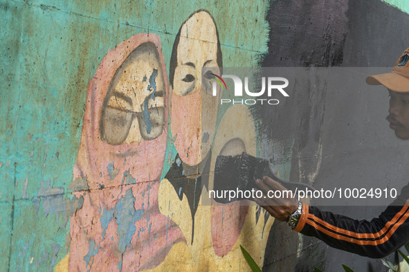 Municipal worker removed a mural promoting awareness of the coronavirus disease (Covid-19) and replaced it with another image in Jakarta, In...