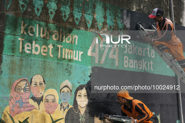 Municipal worker removed a mural promoting awareness of the coronavirus disease (Covid-19) and replaced it with another image in Jakarta, In...