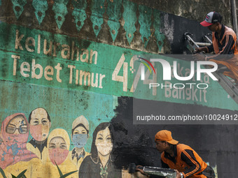 Municipal worker removed a mural promoting awareness of the coronavirus disease (Covid-19) and replaced it with another image in Jakarta, In...