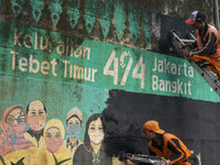 Municipal worker removed a mural promoting awareness of the coronavirus disease (Covid-19) and replaced it with another image in Jakarta, In...