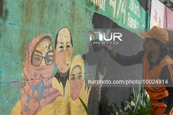 Municipal worker removed a mural promoting awareness of the coronavirus disease (Covid-19) and replaced it with another image in Jakarta, In...