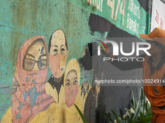 Municipal worker removed a mural promoting awareness of the coronavirus disease (Covid-19) and replaced it with another image in Jakarta, In...