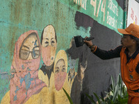 Municipal worker removed a mural promoting awareness of the coronavirus disease (Covid-19) and replaced it with another image in Jakarta, In...