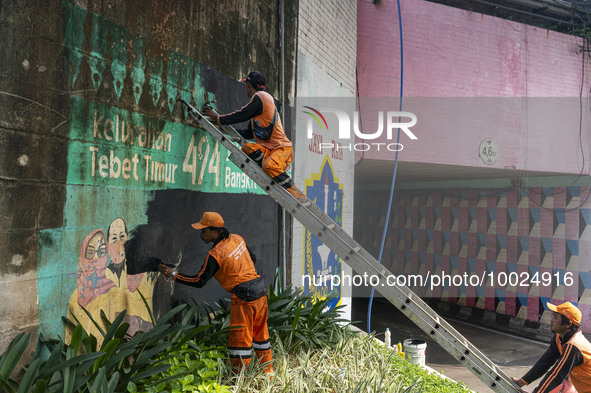 Municipal worker removed a mural promoting awareness of the coronavirus disease (Covid-19) and replaced it with another image in Jakarta, In...