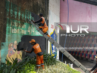 Municipal worker removed a mural promoting awareness of the coronavirus disease (Covid-19) and replaced it with another image in Jakarta, In...