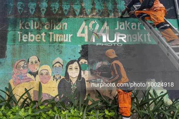 Municipal worker removed a mural promoting awareness of the coronavirus disease (Covid-19) and replaced it with another image in Jakarta, In...