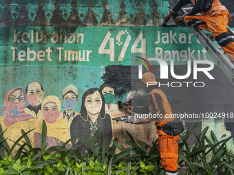 Municipal worker removed a mural promoting awareness of the coronavirus disease (Covid-19) and replaced it with another image in Jakarta, In...