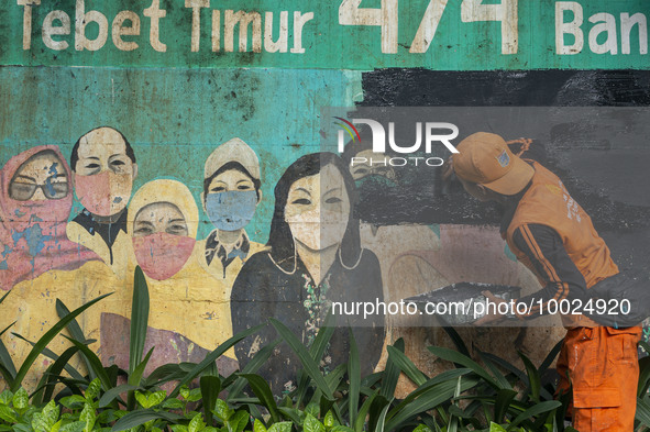 Municipal worker removed a mural promoting awareness of the coronavirus disease (Covid-19) and replaced it with another image in Jakarta, In...