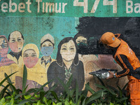 Municipal worker removed a mural promoting awareness of the coronavirus disease (Covid-19) and replaced it with another image in Jakarta, In...