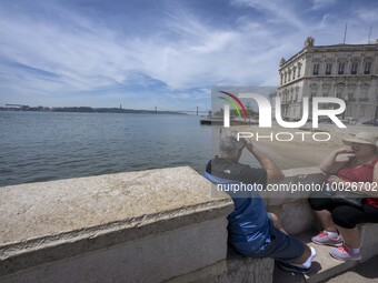 Several people are seen resting near the Tejo river bank, in the neighborhood of Baixa, Lisbon. 02 May 2023. (