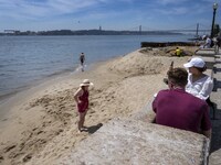 Several people are seen resting near a beach on the Tejo river, in the Baixa neighborhood, Lisbon. 02 May 2023. (