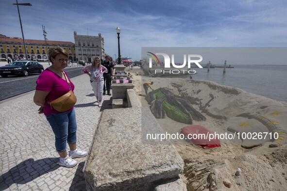 Several people are seen looking at sculptures on the riverbank near a beach on the Tejo river, in the Baixa neighborhood, Lisbon. 02 May 202...