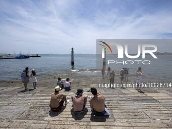 Several people are seen resting on the banks of the Tejo river, in the neighborhood of Baixa, Lisbon. 02 May 2023. (