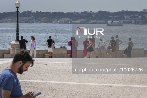 Several people are seen resting on the banks of the Tejo river, in the neighborhood of Baixa, Lisbon. 02 May 2023. 