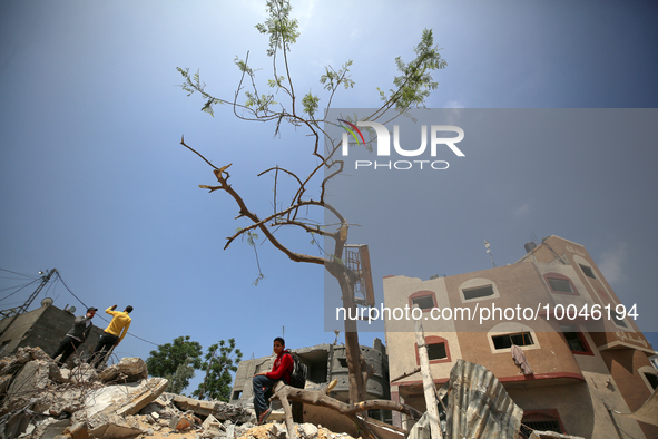 A Palestinian school student sits amidst the rubble of his house in Gaza City, on May 15, 2023, following a ceasefire ending five days of de...