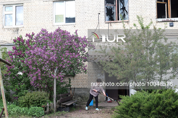 ZOLOCHIV, UKRAINE - MAY 14, 2023 - A woman shovels away the debris after the rocket attack by Russia that, allegedly, used S-300 surface-to-...