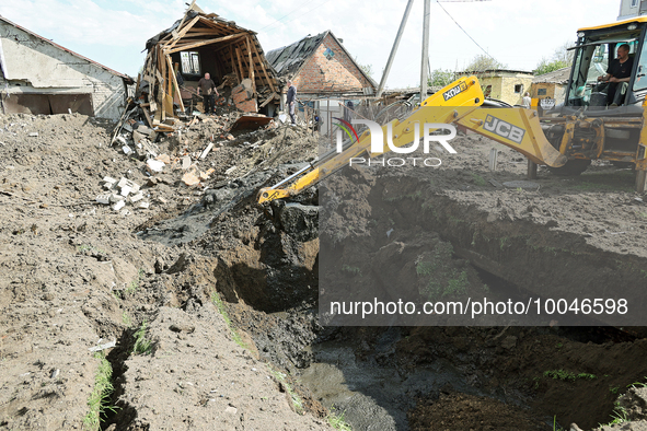 ZOLOCHIV, UKRAINE - MAY 14, 2023 - An excavator digs the ground after the rocket attack by Russia that, allegedly, used S-300 surface-to-air...