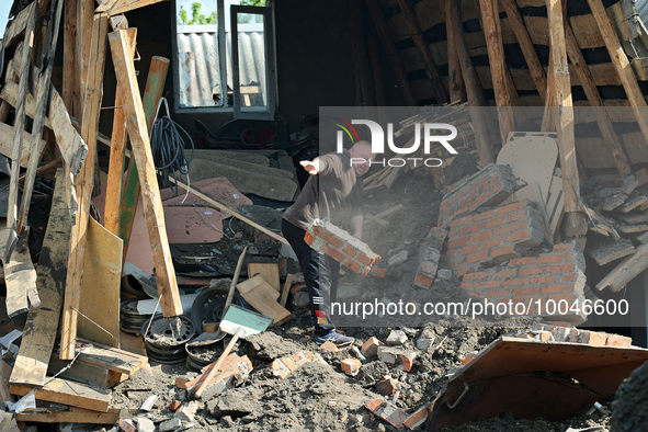 ZOLOCHIV, UKRAINE - MAY 14, 2023 - A man clears away the rubble after the rocket attack by Russia that, allegedly, used S-300 surface-to-air...