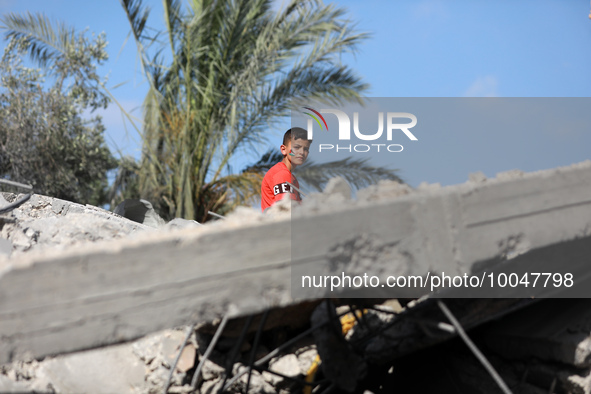 A Palestinian boy sits amidst the rubble of a destroyed building in Deir al-Balah in central Gaza Strip on May 15, 2023 following a ceasefir...