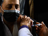 A man recieves a dose of Vaccine during Hajj pilgrimage vaccination program in Sopore District Baramulla Jammu and Kashmir India on 16 May 2...