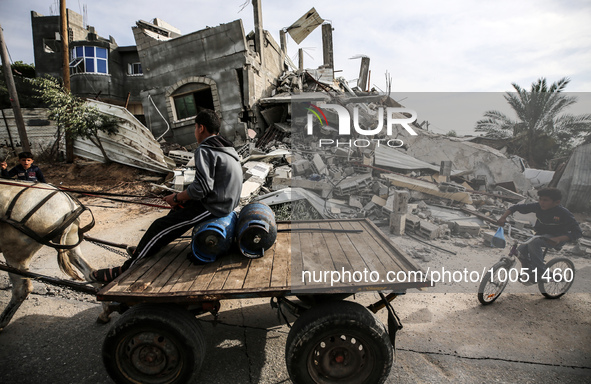 A Palestinian man rides his donkey cart past amidst the rubble of his house in Beit Lahia in the northern Gaza Strip, on May 16, 2023, follo...