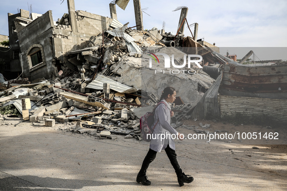 A Palestinian student walks past amidst the rubble of his house in Beit Lahia in the northern Gaza Strip, on May 16, 2023, following a cease...