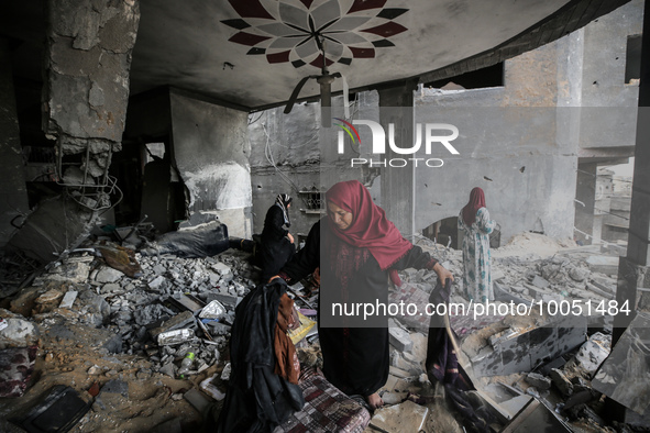 Palestinians inspect their belongings amidst the rubble of their house in Beit Lahia in the northern Gaza Strip, on May 16, 2023, following...