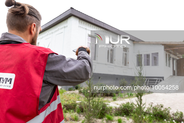 A volunteer from Gurtum foundation stands by the school which his NGO reconstructs after the building was damaged by at least 3 bombs in Hos...