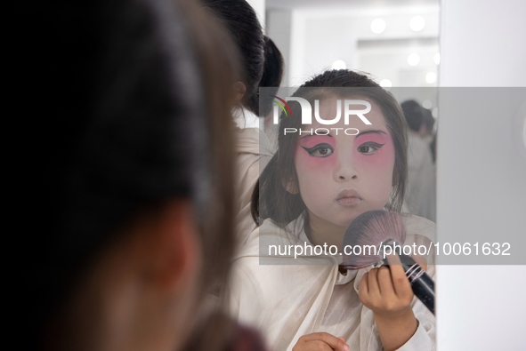  A young performer touches up her makeup at a primary school Peking Opera club in Hai 'an, East China's Jiangsu province, May 20, 2023. 