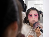  A young performer touches up her makeup at a primary school Peking Opera club in Hai 'an, East China's Jiangsu province, May 20, 2023. (