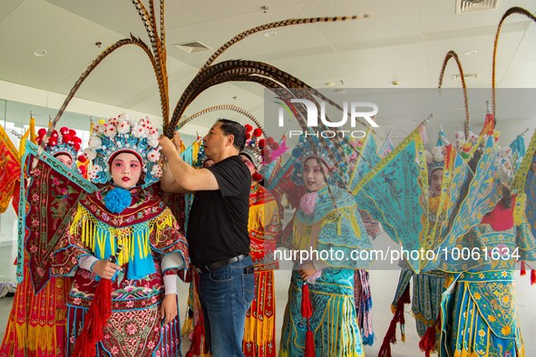  A Peking Opera teacher dresses students in costumes at a primary school Peking Opera club in Hai 'an, East China's Jiangsu province, May 20...