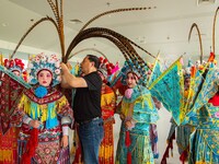  A Peking Opera teacher dresses students in costumes at a primary school Peking Opera club in Hai 'an, East China's Jiangsu province, May 20...