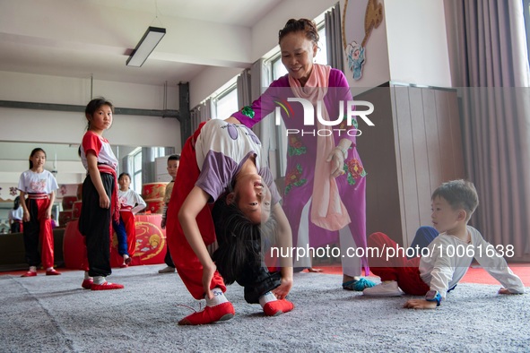  A teacher of a primary school Peking Opera club instructs students to practice basic skills in Hai 'an, East China's Jiangsu province, May...